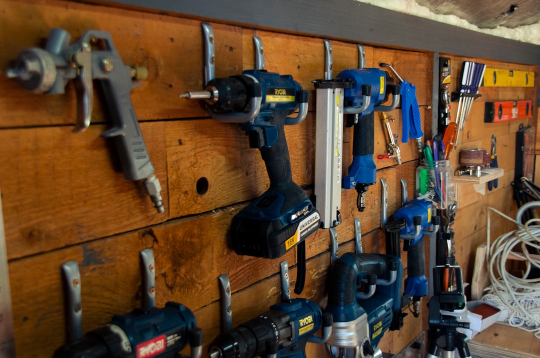 A wall of cordless garden power tools on their chargers